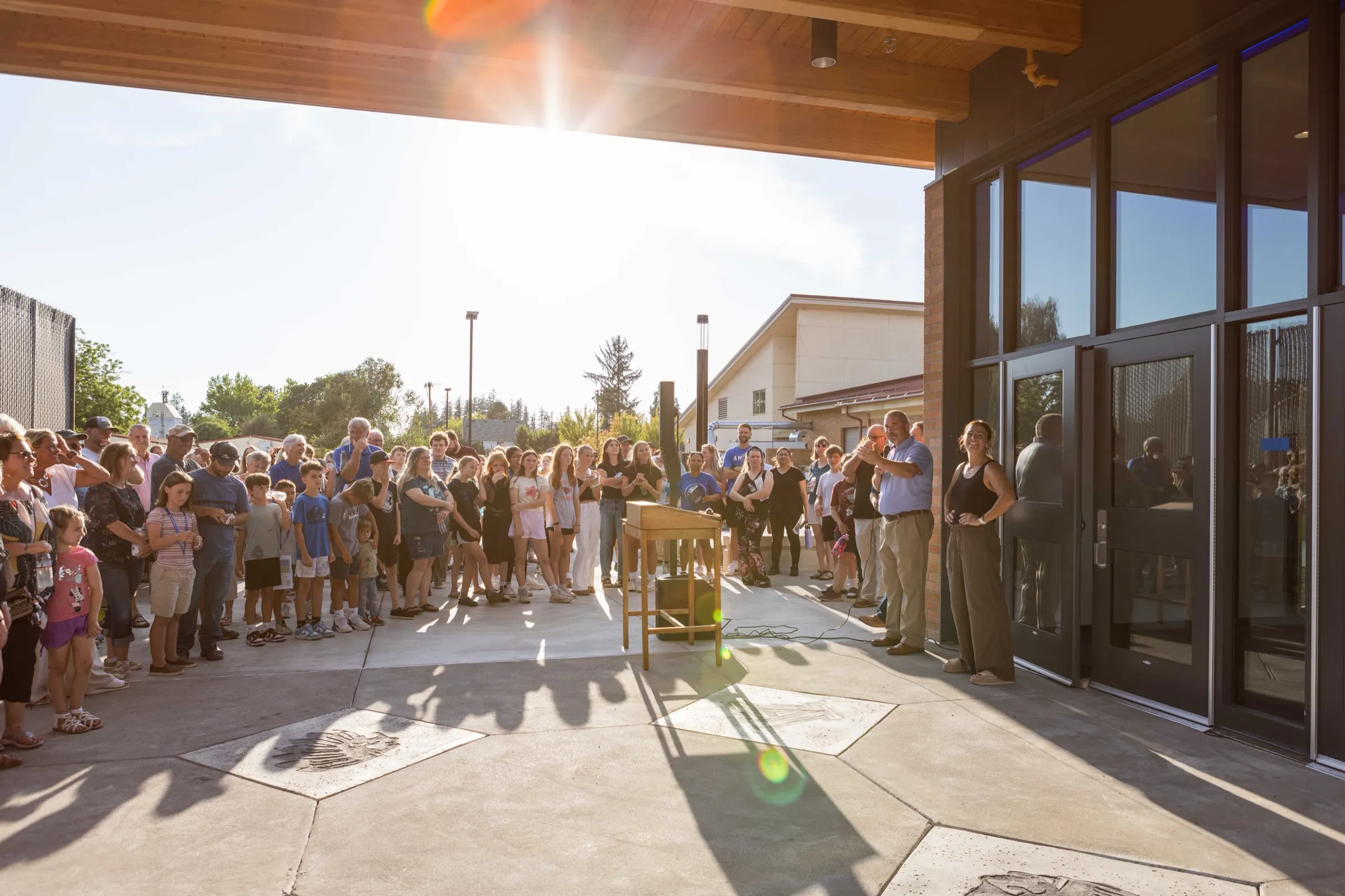 Families, students and staff gather outside the new school building for its opening ceremony.
